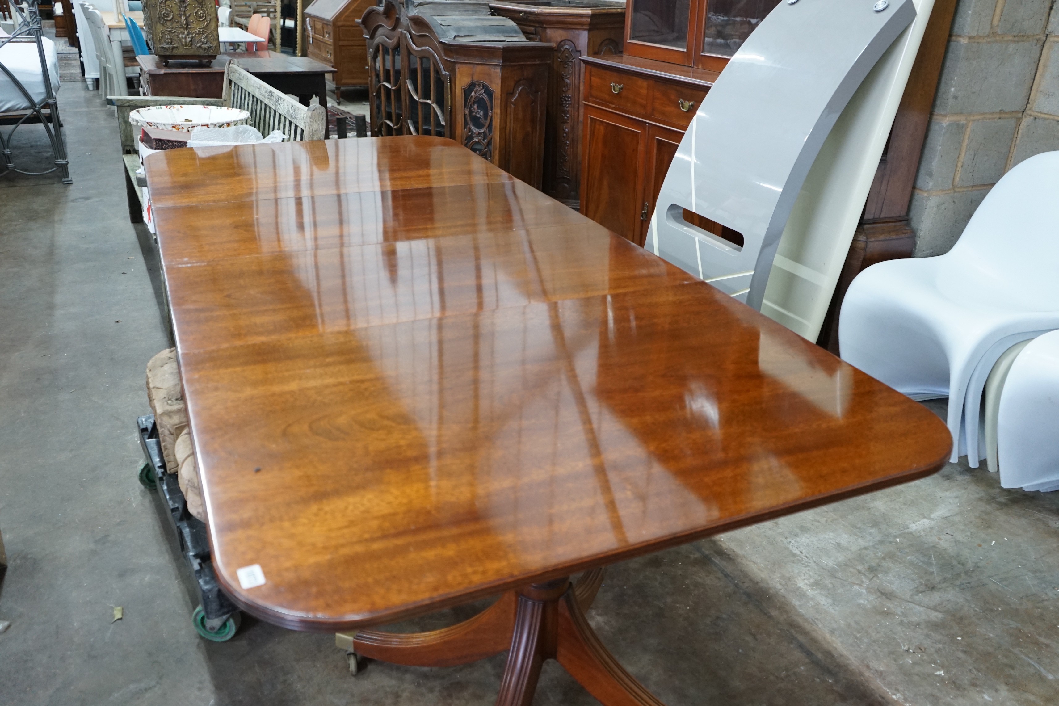 A reproduction Tillman style mahogany twin pillar extending dining table 246cms extended, two spare leaves, width 107cms, height 72cms.